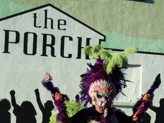 A full dress Mardi Gras Indian stands outside The Porch