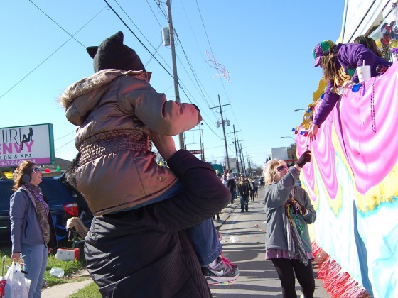 bundled up kids on piggyback approach carnival float