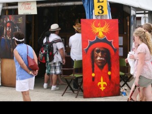 Jazz Festers peruse original art by NOLA artist Joshua Walsh. Photo-Jef Jaisun.